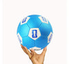 Blue soccer ball with FIFA logo held in a hand against a white background